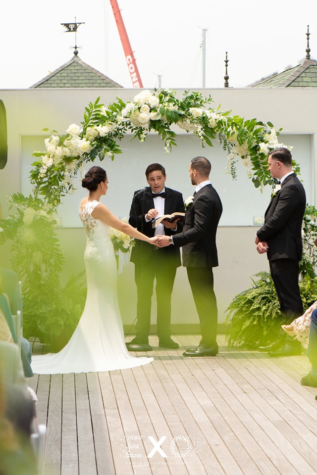 bride and groom under ceremonial arch