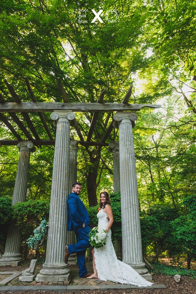 bride and groom posing by columns