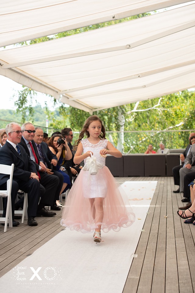 flower girl walking down the aisle at Harbor Club at Prime