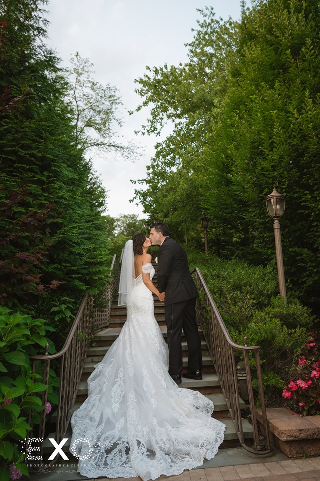 bride and groom kissing on steps at Crest Hollow Country Club