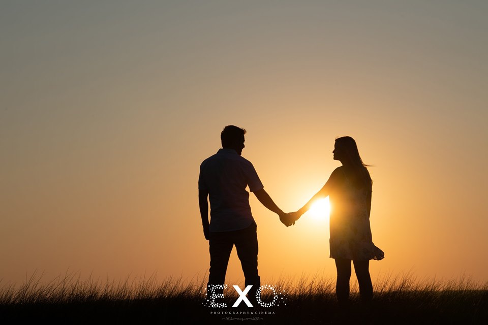 couple holding hands at sunset
