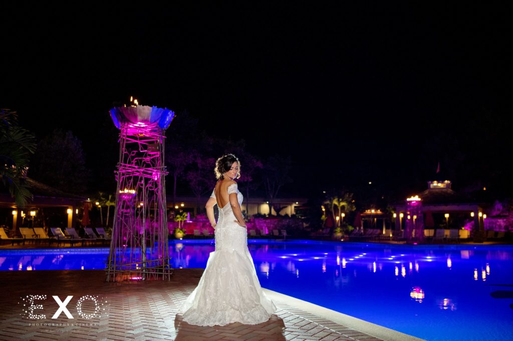 bride outside by the pool at night at Crest Hollow Country Club