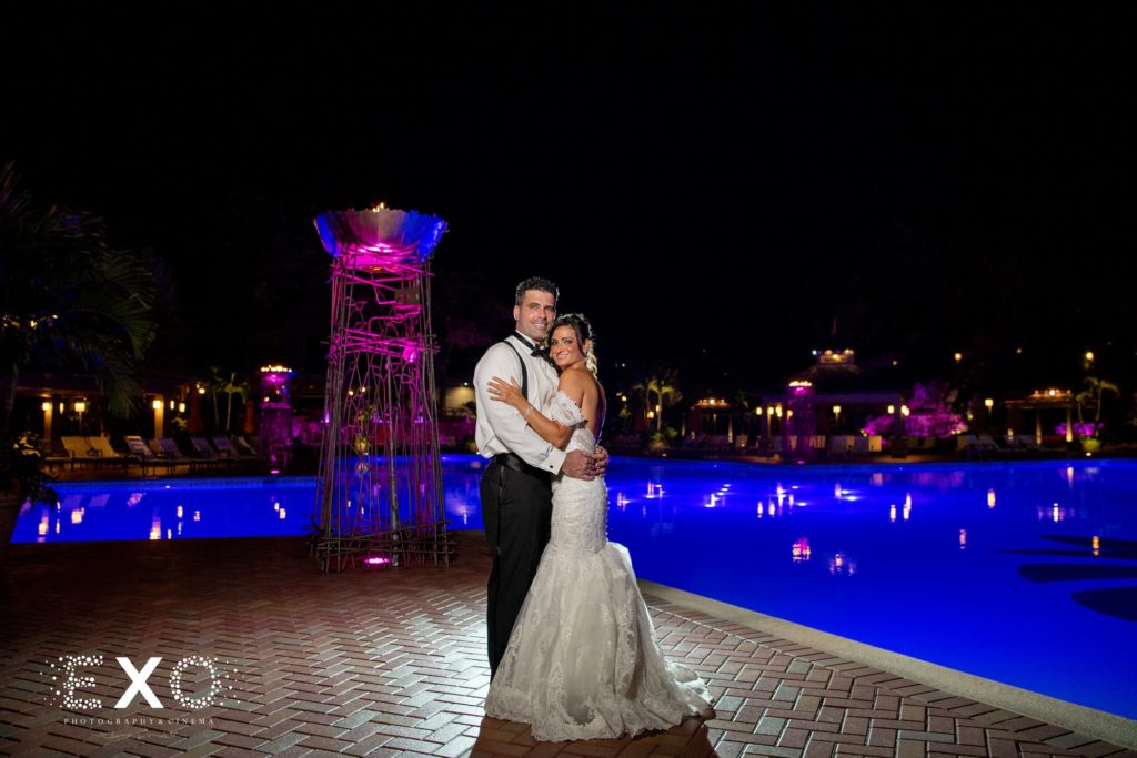 bride and groom by the pool at night at Crest Hollow Country Club