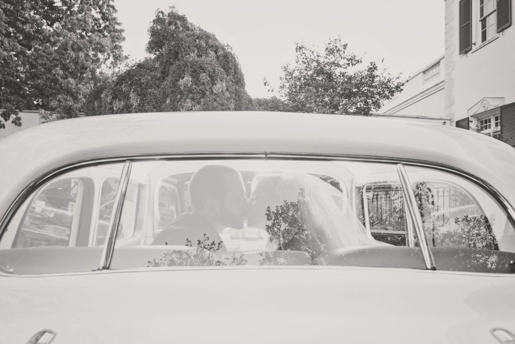 bride and groom kissing in car on way to The Mansion at Oyster Bay