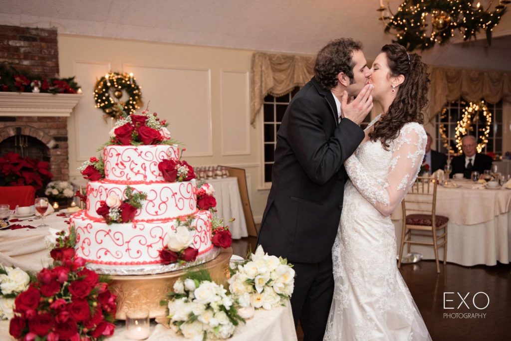 bride and groom kissing after cutting the cake at The Milleridge Cottage