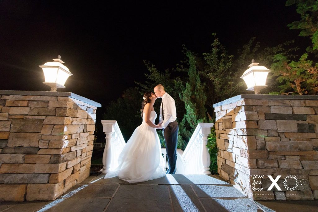bride and groom kissing outside Willow Creek Golf and Country Club at night