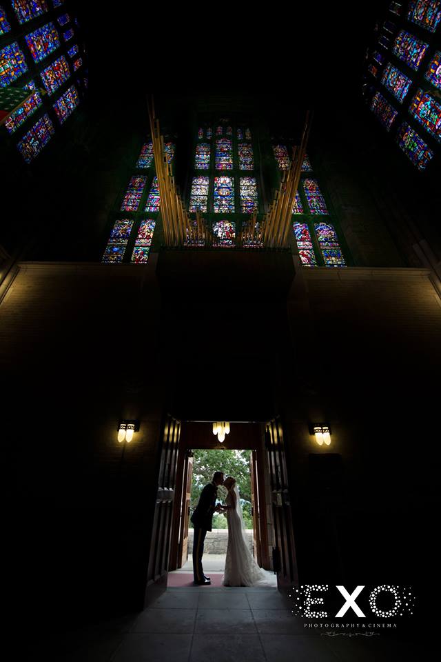 bride and groom kissing in doorway at their church