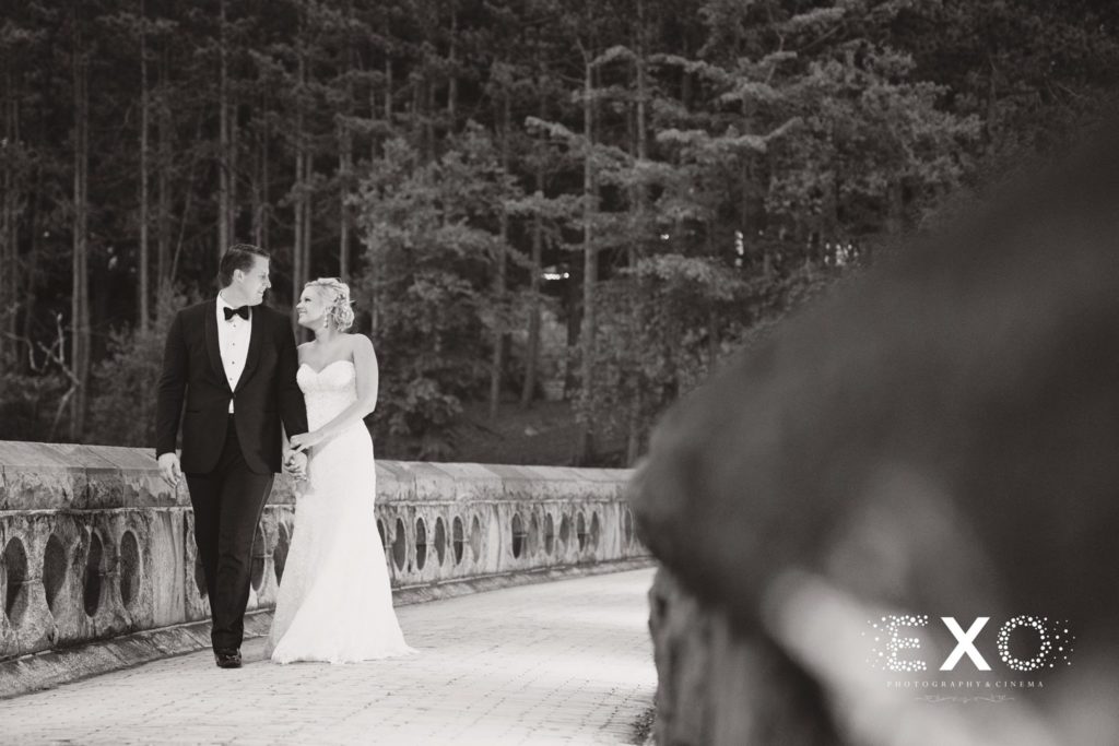 bride and groom walking along the bridge outside The Thayer Hotel at night