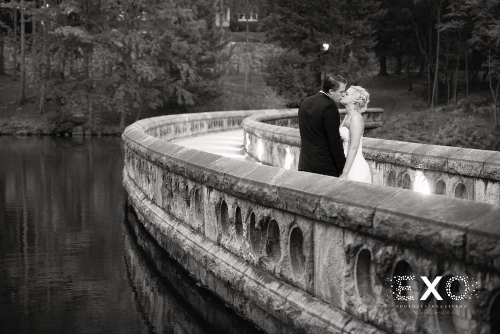 bride and groom kissing on bridge outside The Thayer Hotel
