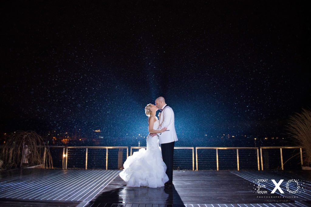 bride and groom kissing outside Harbor Club at Prime at night