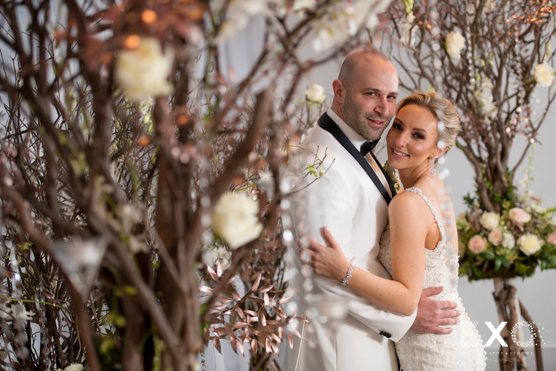 bride and groom posing within centerpieces at Harbor Club at Prime