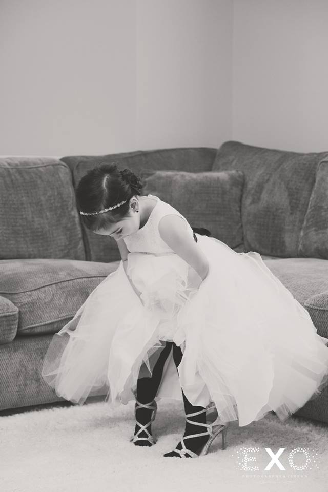 flower girl trying on brides shoes