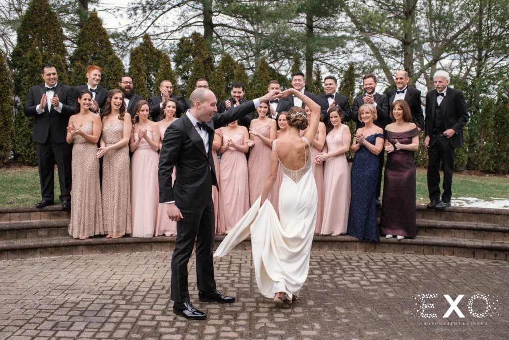 bride and groom dancing in front of bridal party outside Temple Beth Torah