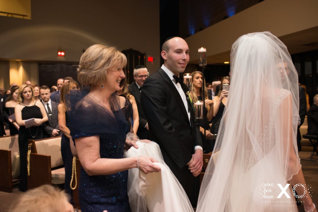 bride walking circles around her husband during ceremony at Temple Beth Torah
