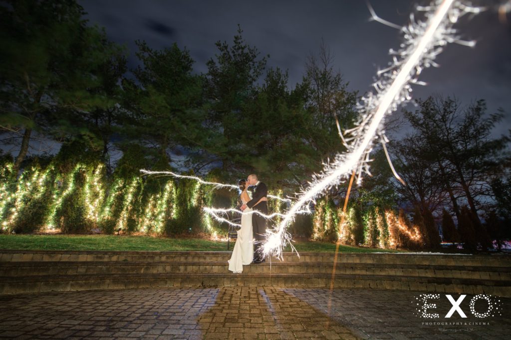 bride and groom kissing at night with lights