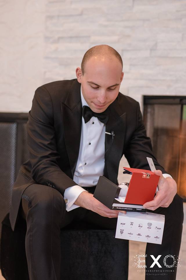 groom opening his gift from his bride at Temple Beth Torah