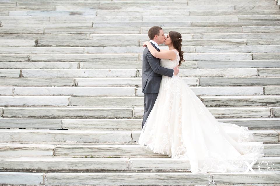 bride and groom kissing on steps outside Bourne Mansion