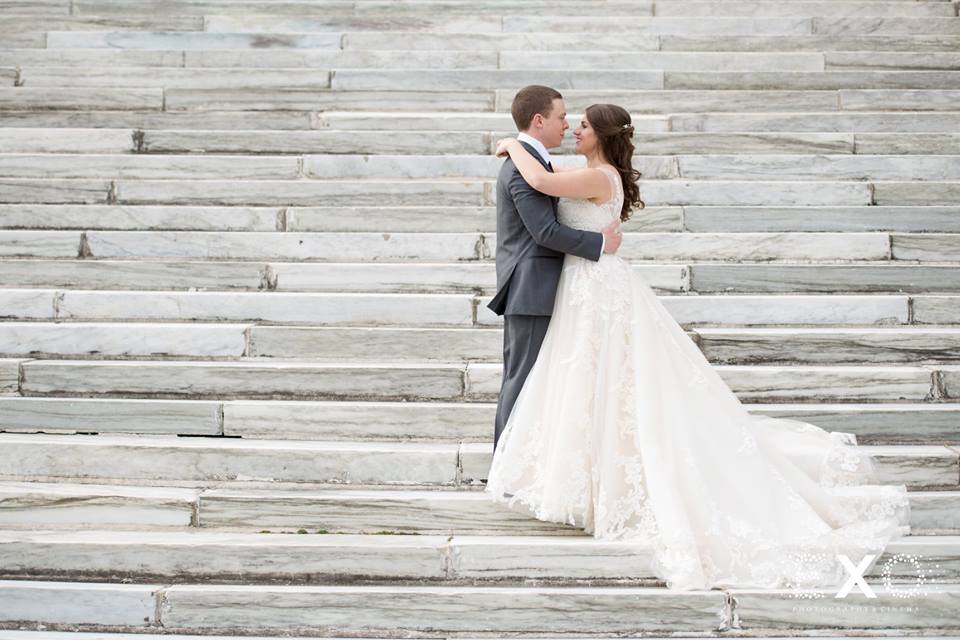 bride and groom on steps of Bourne Mansion