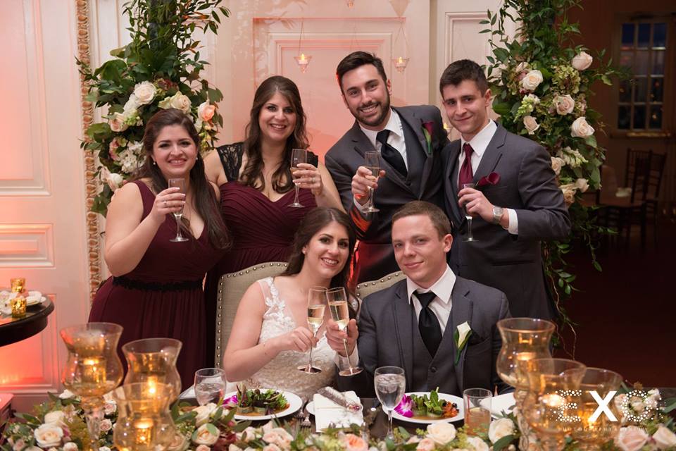 bride and groom toasting with some of the bridal party at Bourne Mansion
