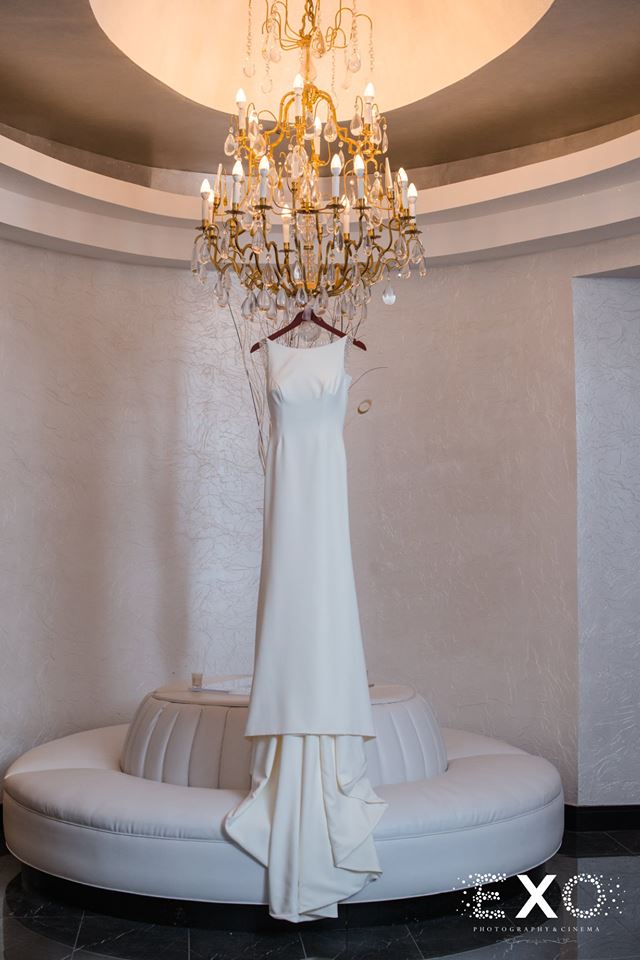 bride's dress hanging from chandelier