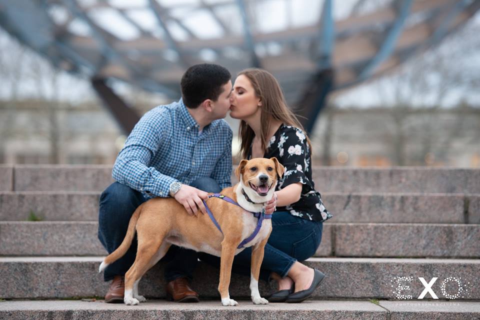 couple kissing with dog posing at Flushing Meadow Park