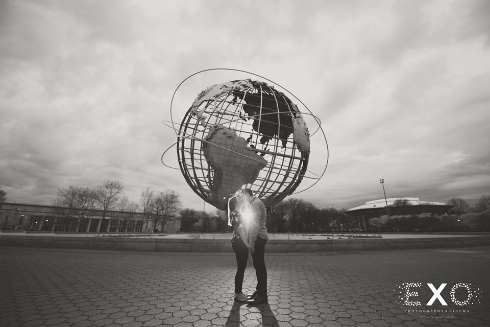 couple kissing by the globe at Flushing Meadow Park