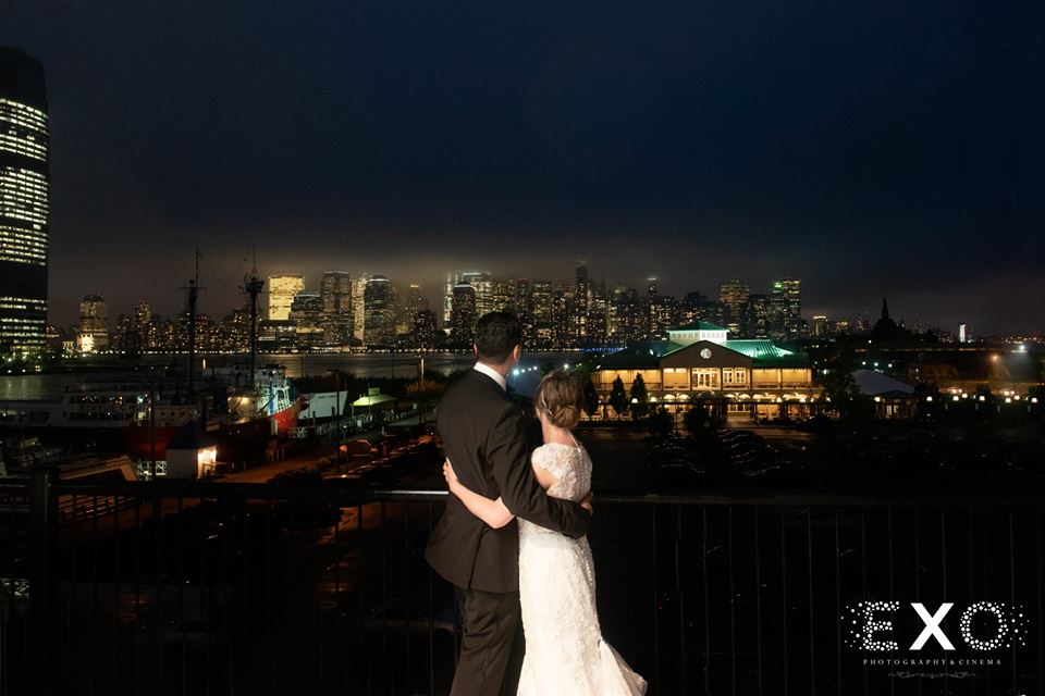 bride and groom on balcony at Maritime Parc looking over at the city