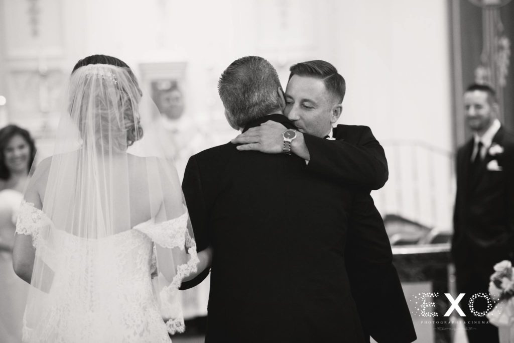groom hugging bride's father at altar