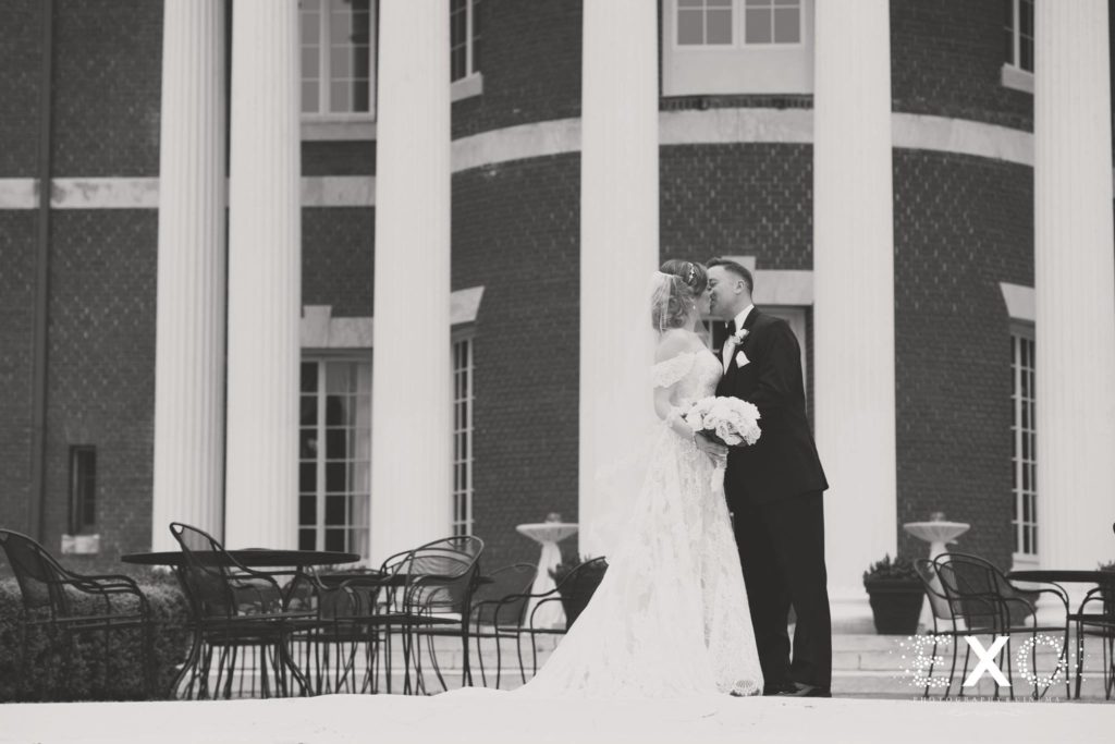 bride and groom kissing outside Bourne Mansion