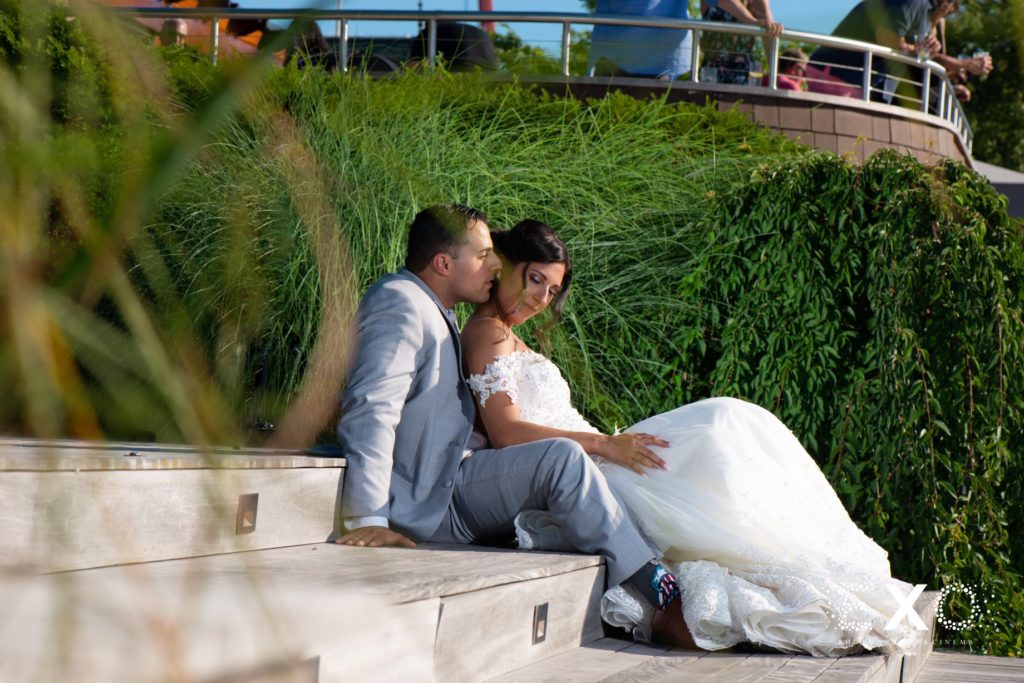 bride and groom sitting on steps outside Harbor Club at Prime