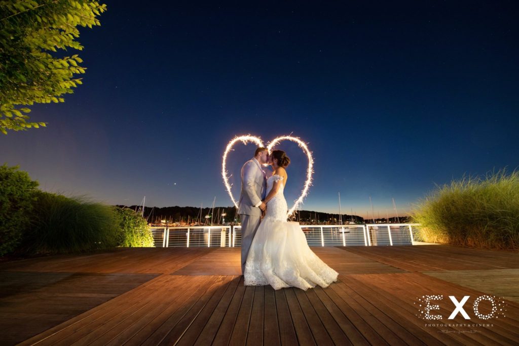 bride and groom kissing outside with heart light