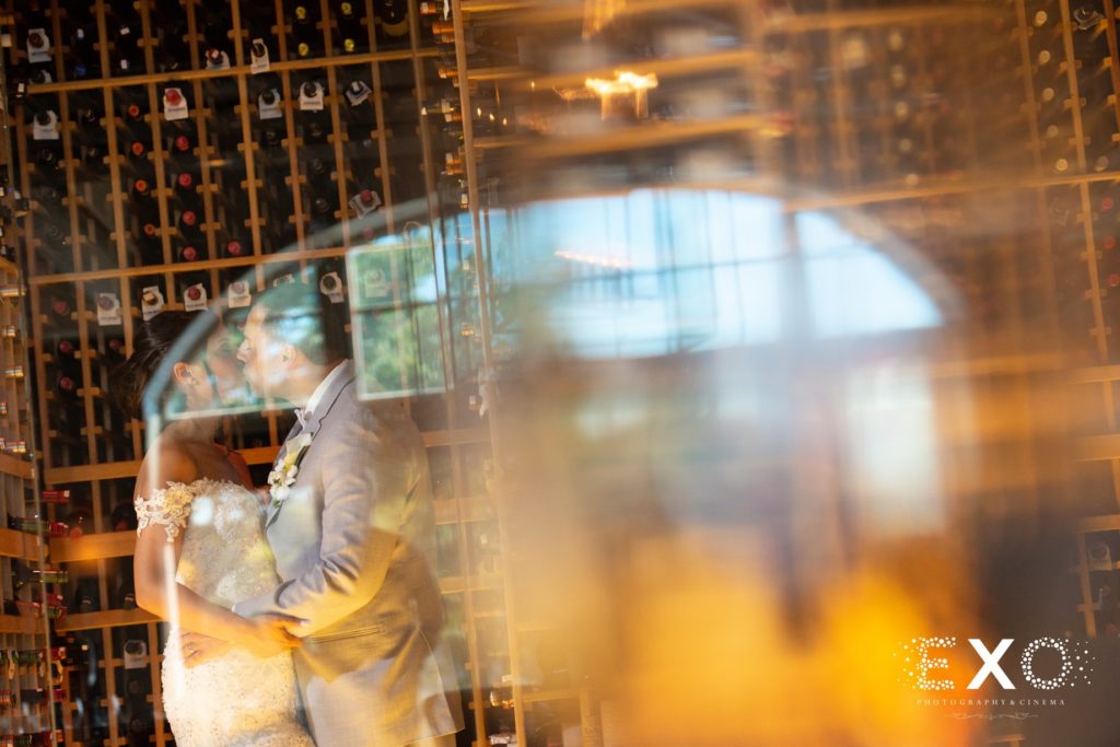 bride and groom kissing in wine cellar at Harbor Club at Prime