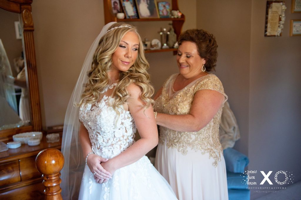 bride's mother helping her with her dress