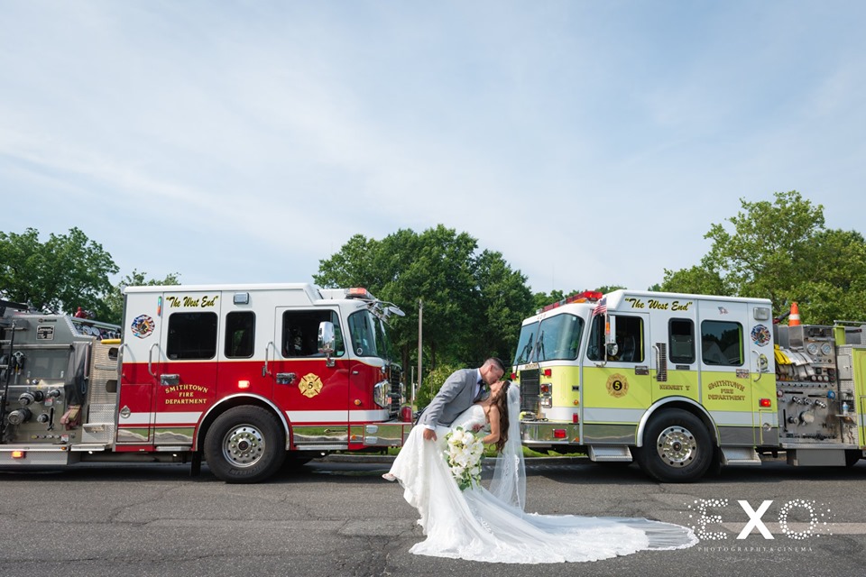 bride and groom kissing outside with fire trucks