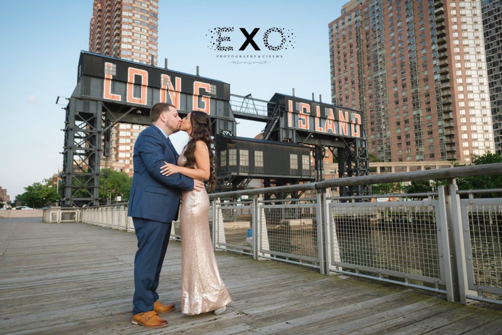 couple kissing in front of Long Island sign at Gantry Plaza State Park