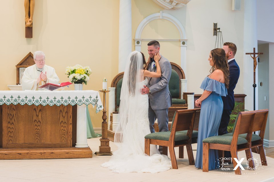 bride and groom kissing at altar