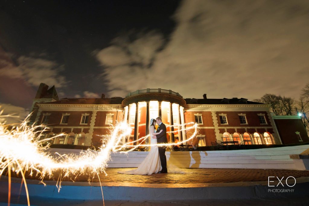 bride and groom outside Bourne Mansion at night