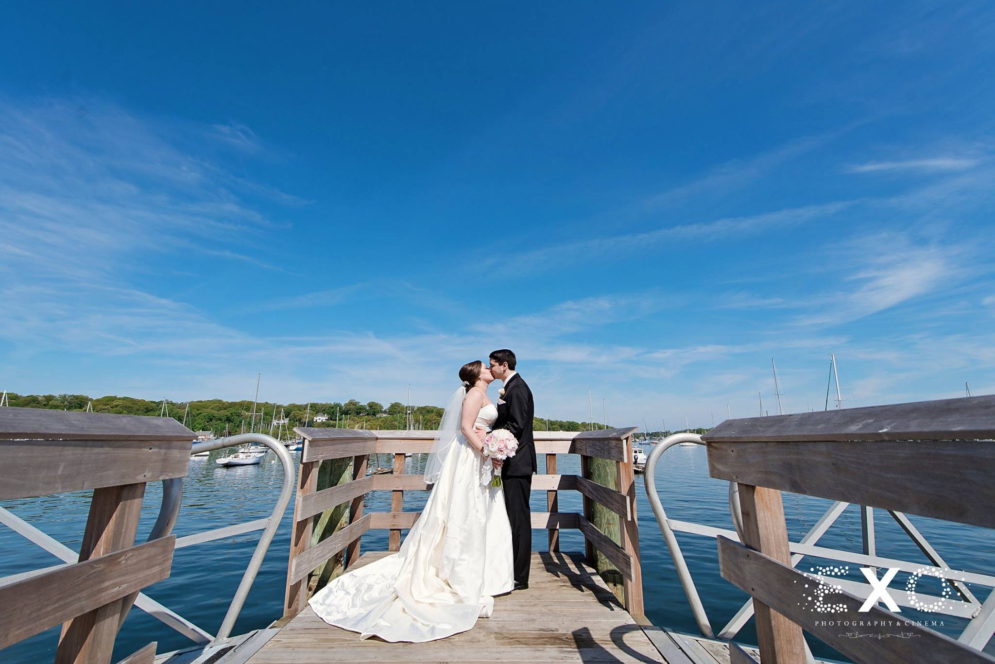 bride and groom kissing on the dock outside Harbor Club at Prime