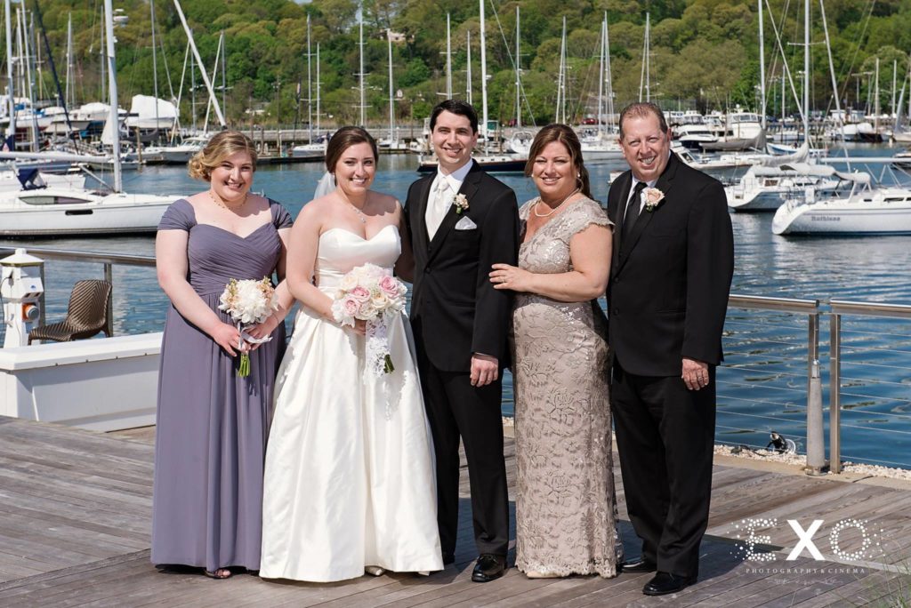 bride and groom with family on dock outside Harbor Club at Prime