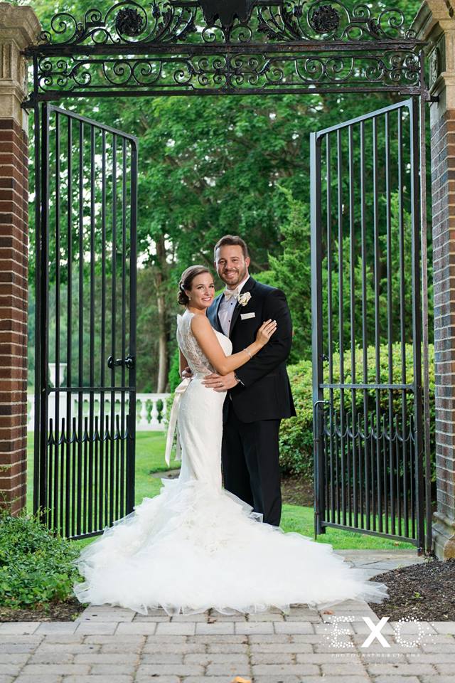 bride and groom posing in gateway at NYIT de Seversky Mansion