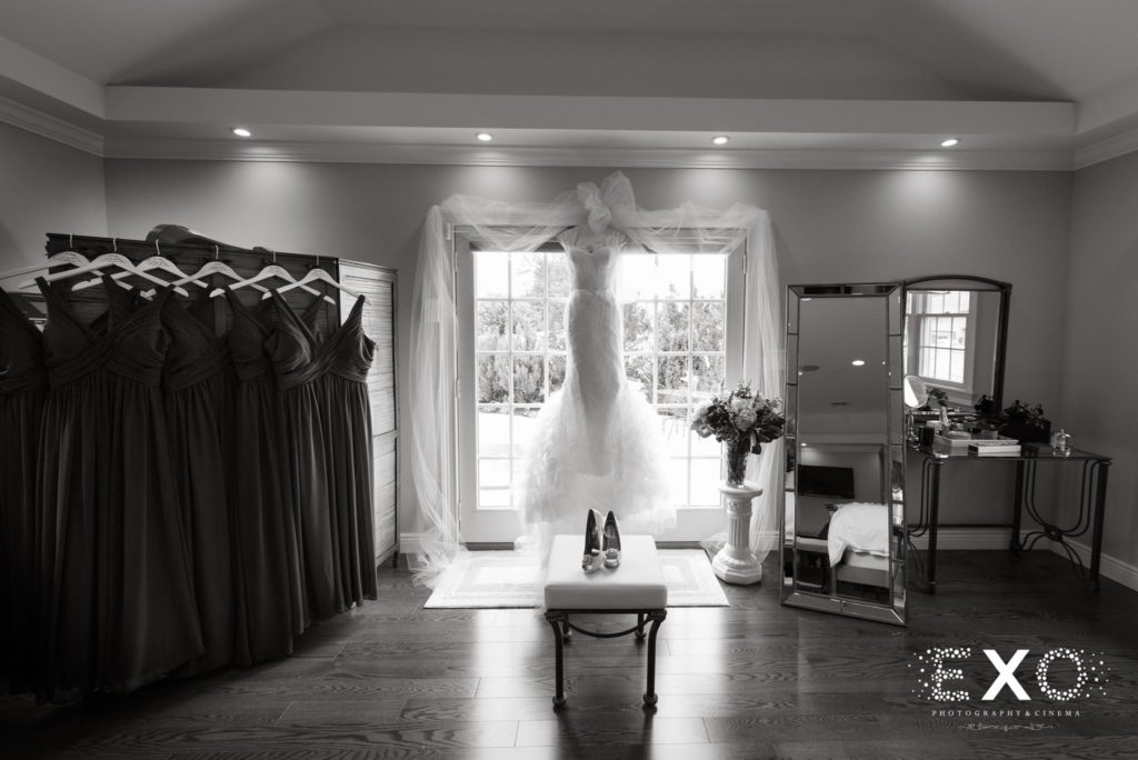 bride's dress hanging in room with bridesmaids' dresses at NYIT de Seversky Mansion