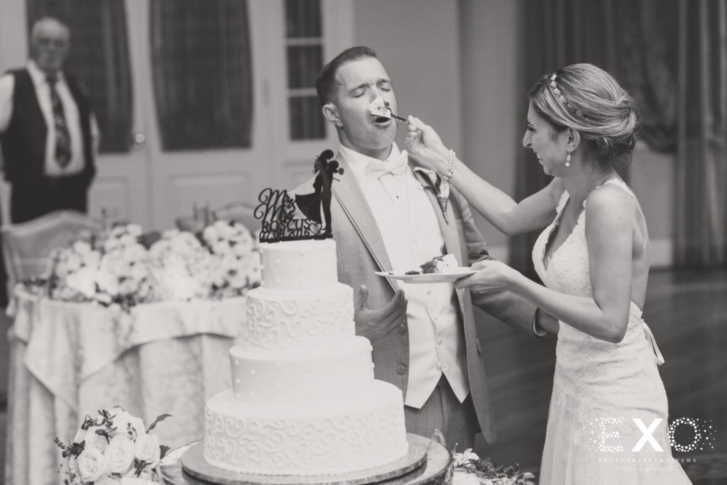 bride putting cake on groom's face at Carlyle on the Green