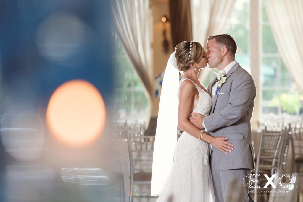bride and groom kissing in the ballroom at Carlyle on the Green