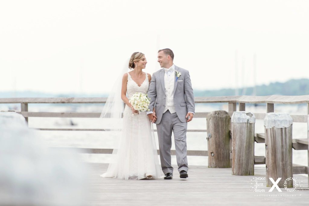 bride and groom walking on boardwalk outside Carlyle on the Green