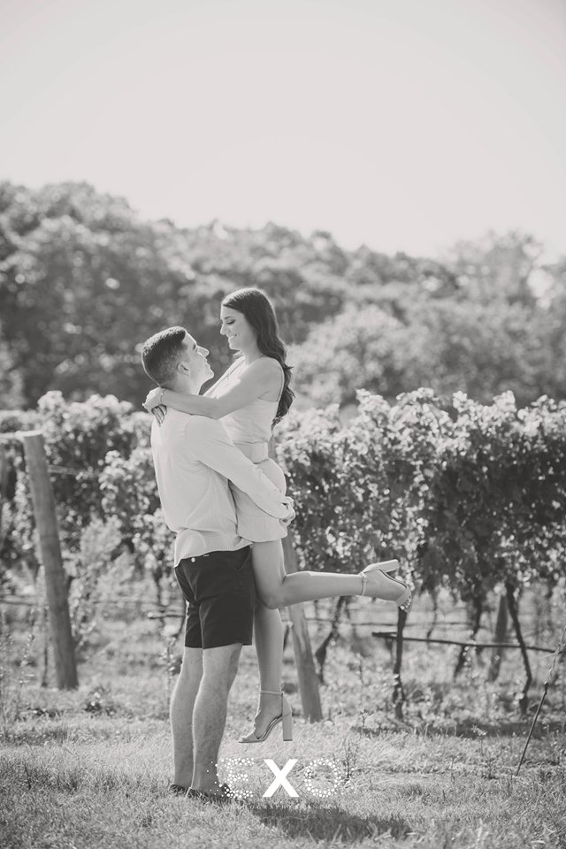 soon-to-be-groom holding his soon-to-be-bride within the vineyards at Pugliese Vineyards