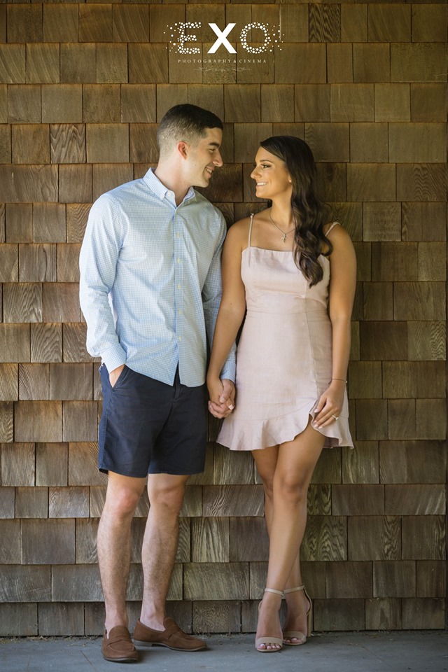 couple holding hands against the wall at Pugliese Vineyards