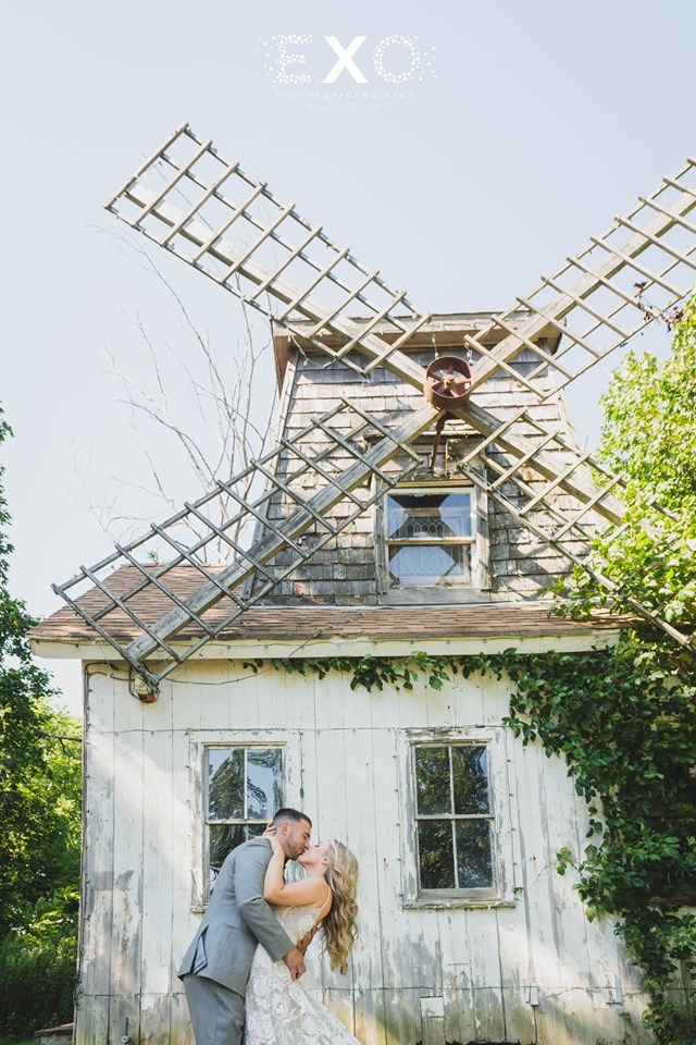 bride and groom kissing by the windmill outside Giorgio's Baiting Hollow