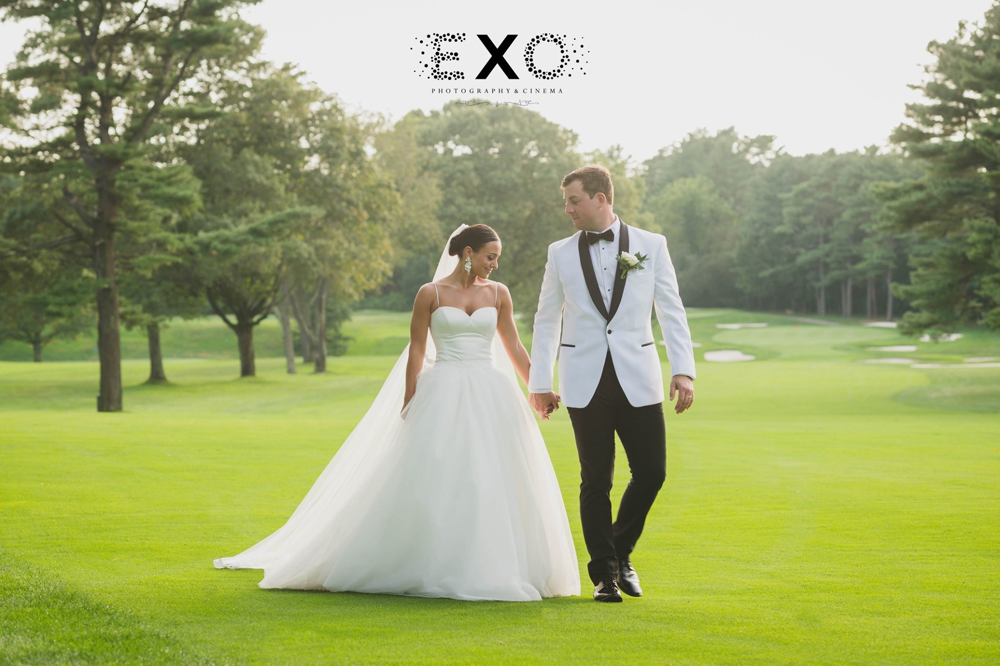 bride and groom walking on the golf course at Muttontown Country Club