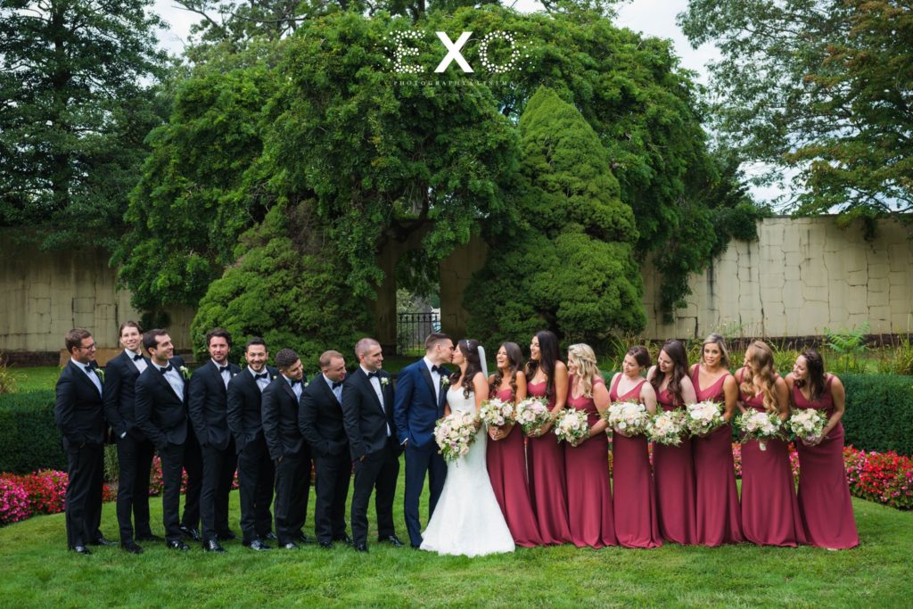 bride and groom with their bridal party outside The Mansion at Oyster Bay