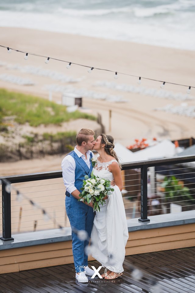 bride and groom kissing on balcony
